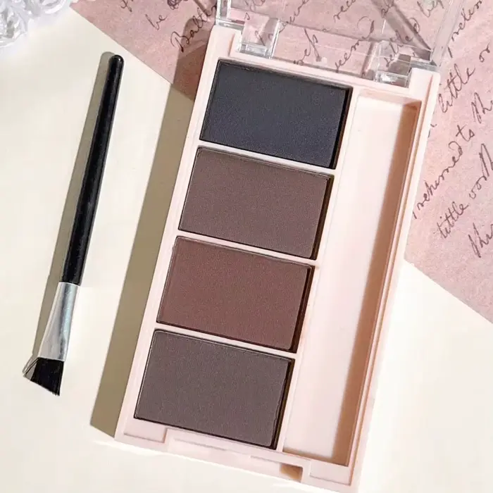 Un ensemble de plateaux de poudre à sourcils de 4 couleurs avec des pinceaux en tons gris et marron mat pour un rendu